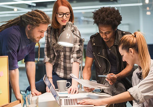 A group of young people spend time together reading up about investing. 