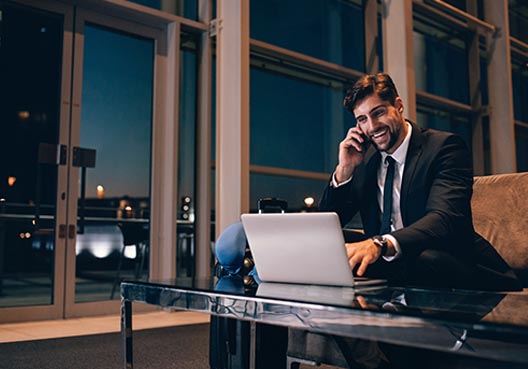 Man talking on his mobile and working on his laptop